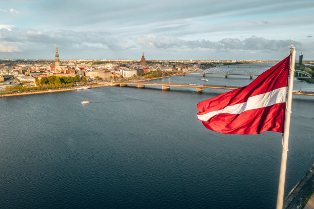 里加市的空中全景图，上面挂着一面巨大的拉脱维亚国旗图片下载