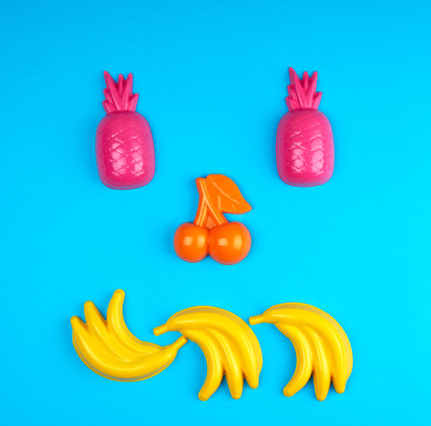 五颜六色的塑料玩具水果在一个蓝色的背景图片下载