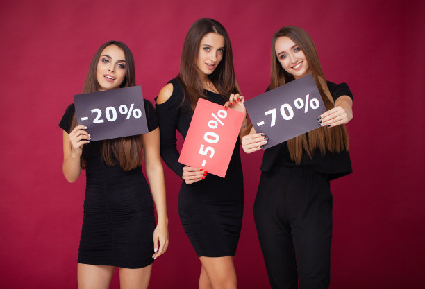 购物。优雅的黑发女人穿着黑色连衣裙拿着购物袋，黑色星期五的概念图片下载