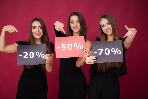 购物。优雅的黑发女人穿着黑色连衣裙拿着购物袋，黑色星期五的概念图片下载