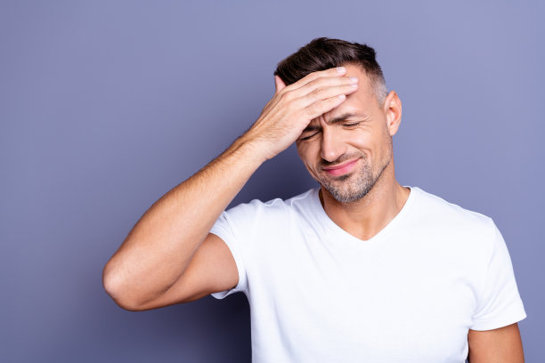 特写照片惊人的他，他，他，中年男子，完美的外表手臂，双手，前额，太阳庙不能忍受可怕的可怕的痛苦，眼睛闭上，穿着休闲的白色t恤孤立的灰色背景图片下载