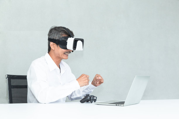 高级商务人士戴着虚拟耳机或3D眼镜在家玩视频游戏。亚洲老年人喜欢戴着VR头盔玩VDO游戏图片下载