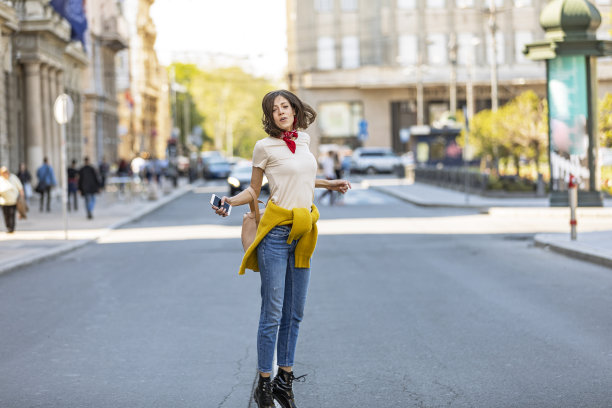 一个快乐女人的肖像。走在城市道路上的年轻女子。快乐的年轻成年妇女微笑着牙齿在户外和走在城市的街道上。图片下载
