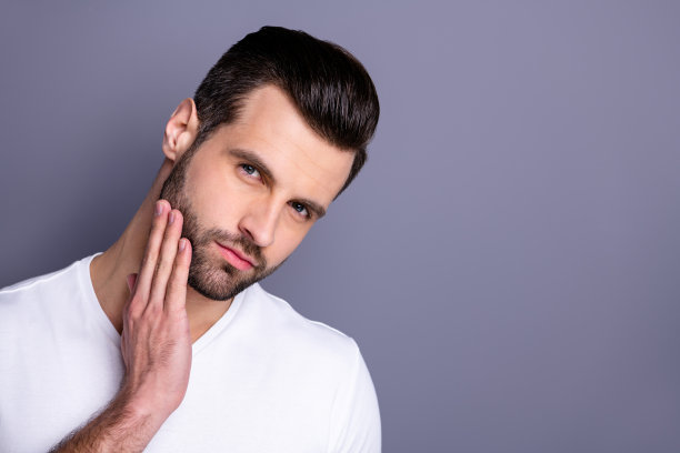 近距离的照片惊人的他他他的男子气概完美的外表触摸手臂手整齐的刚毛脸冷静不微笑沉思的看镜子洗澡淋浴穿休闲的白色t恤孤立的灰色背景图片下载