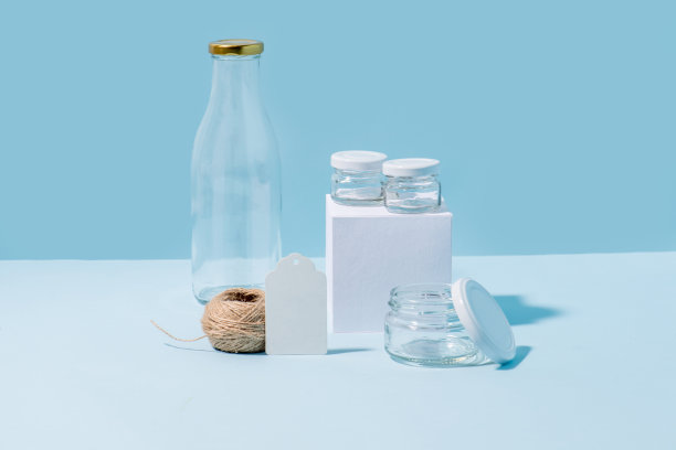 蓝色背景上有一捆麻绳的玻璃瓶和罐子。图片下载