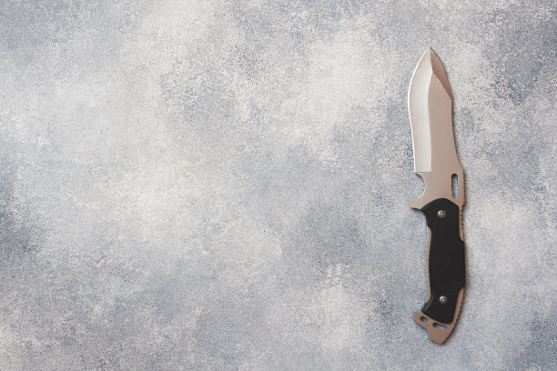 灰色混凝土背景上用于狩猎和旅游的钢刀。图片下载