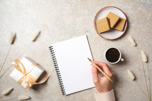 现代简约的家庭工作桌，在空白纸笔记本上手写文本信息，在混凝土石头背景上写华夫饼和干花。平躺风格，俯视图时尚生活博客英雄图片下载