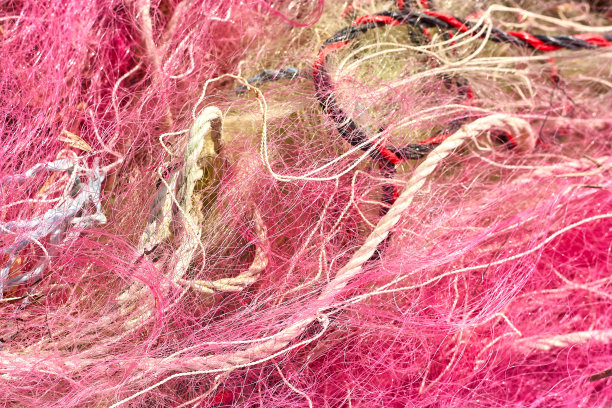 一堆乱七八糟的渔网、塑料绳子和其他碎片被冲上了海岸海滩。图片下载