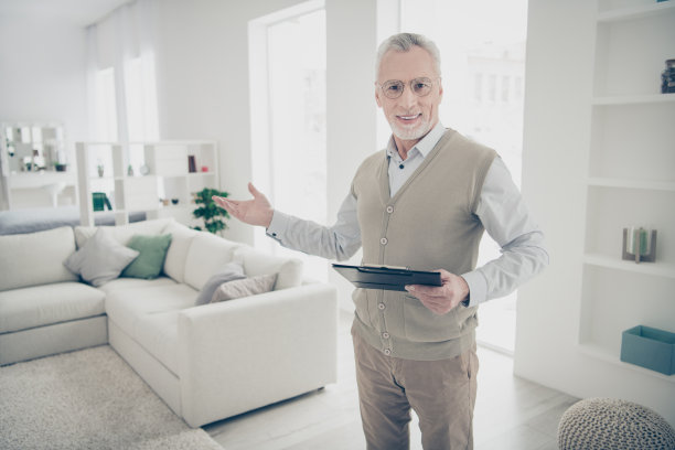 近距离的照片惊人的，他，他，他的老人手臂，手显示干净的空间熟练的专家，握笔，通知合同细节，穿白色的衬衫，背心，裤子，舒适明亮的公寓房子，客厅在室内图片下载