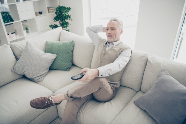 近距离的侧面资料照片惊人的，时髦的，他，他，他的老人手臂，手，控制台，更换电视频道，媒体，穿眼镜，白色衬衫，背心，裤子，坐舒适明亮的公寓，房子，客厅，室内图片下载