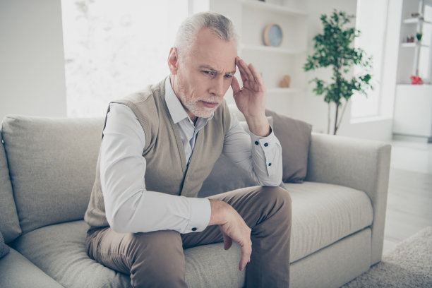 近距离的照片令人惊讶的他他他的老人沉默的平静的平静的样子奇怪的思考在手手臂寺庙不确定的怀疑穿着白色的衬衫背心裤子坐在舒适的沙发公寓客厅在室内图片下载