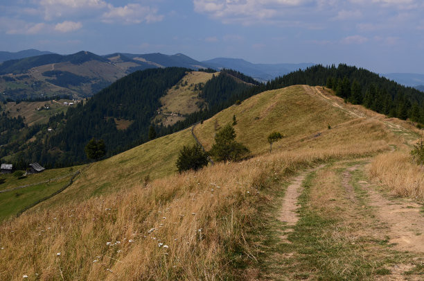 高山上的土路通往山谷里的村庄图片下载
