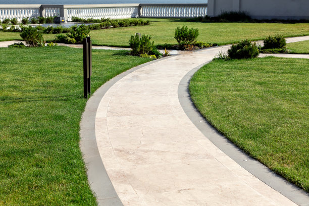 大理石人行道在后院公园与绿色的草坪和栏杆在背景，一个空的无人花园放松在一个阳光明媚的夏天。图片下载