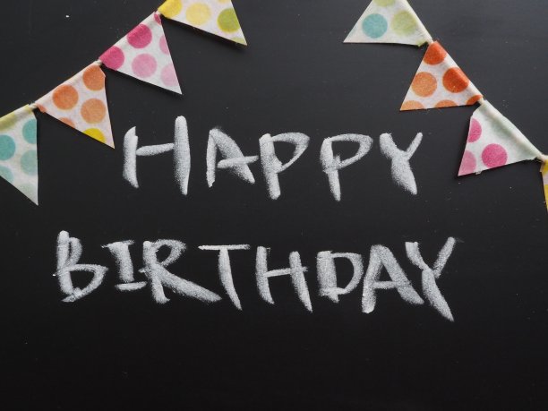 彩色生日派对旗花环与“生日快乐”的消息在黑板上图片下载