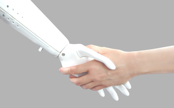 人的手和机器手。握手。网络通信概念孤立在灰色背景下。未来的技术。图片下载