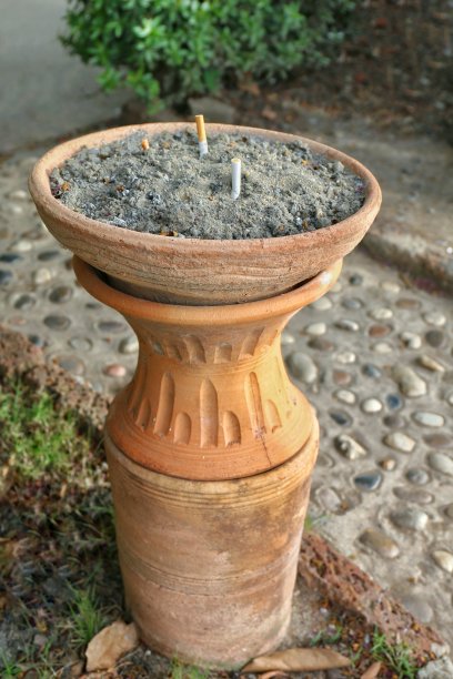 烟灰缸是街道地面花园上的陶土香烟，吸烟，危害烟灰缸的心脏和健康图片下载