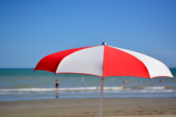 在大海和蓝天前撑一把沙滩伞图片下载