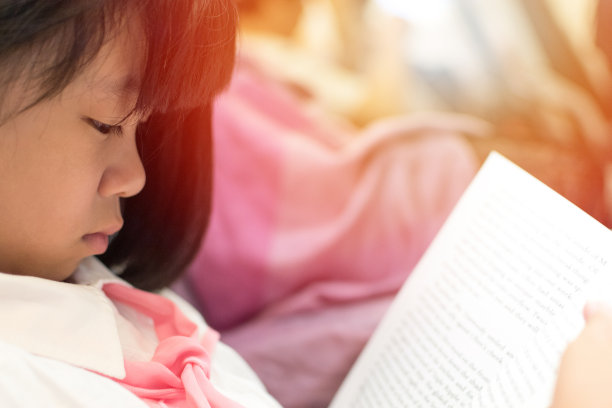 亚洲小女孩在家看书。女可爱的孩子集中精力读少年小说。亚洲学生为了考试而学习教科书。世界读书日与教育理念。图片下载