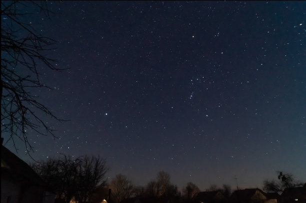 这是一张村庄和夜空的长时间曝光的低光照片。村子离城市很远，天上有很多星星和星座。深空的库存照片。图片下载