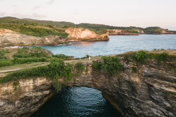 风景的女人站在破碎的海滩拱门努沙佩尼达图片下载