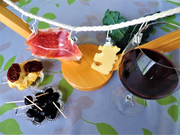 开胃菜安装。葡萄酒，奶酪，火腿，橄榄，番茄干和一小片面包。图片下载