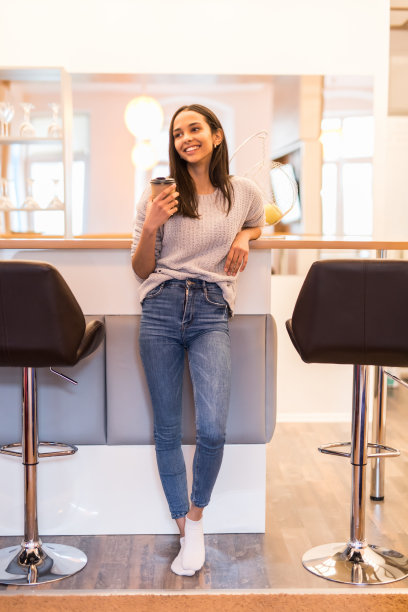 微笑随意的女人在厨房喝咖啡的肖像图片下载