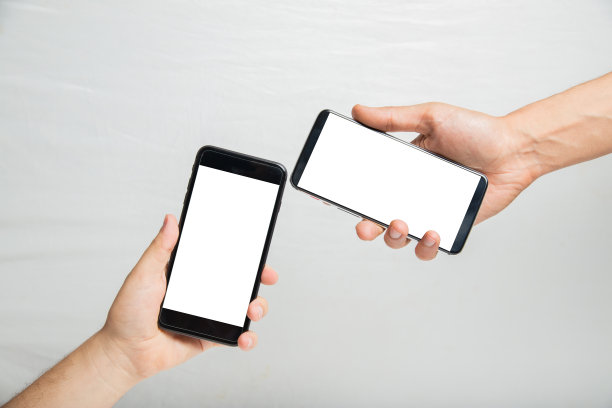 近手的两个年轻人用智能手机与空白白屏幕为您的广告图片或短信。图片下载