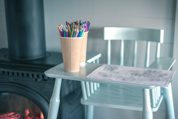 彩色铅笔在高椅子上。靠近灼热的壁炉。也是画画和有创造力的孩子们的舒适的地方。关闭了。图片下载