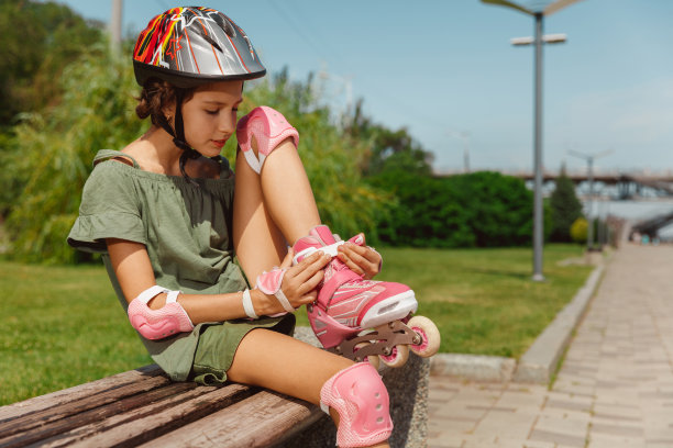 戴着头盔的少女在户外学习滑旱冰鞋图片下载