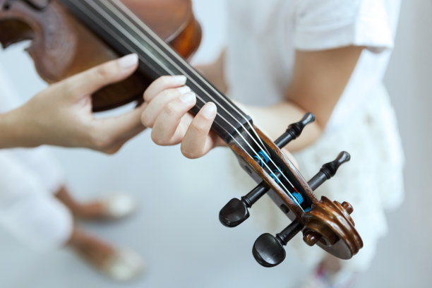 老师的手帮助孩子的手拉小提琴图片下载