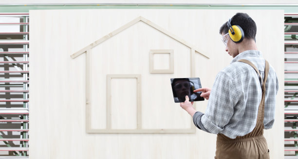 房屋建筑改造概念杂工木工触摸屏数字平板，隔木房子的模型隔在白色木质背景上图片下载