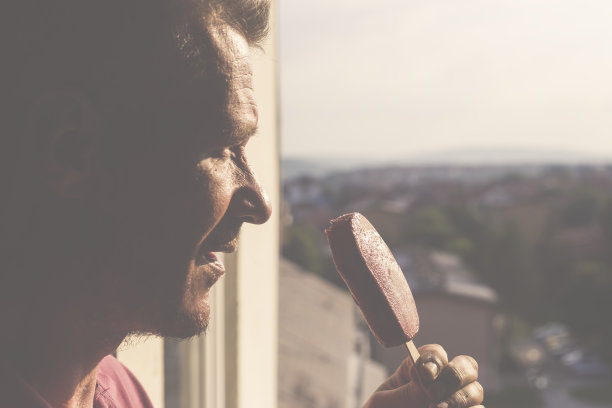 在阳光明媚的夏日，用红色的冰淇淋棒来提神图片下载