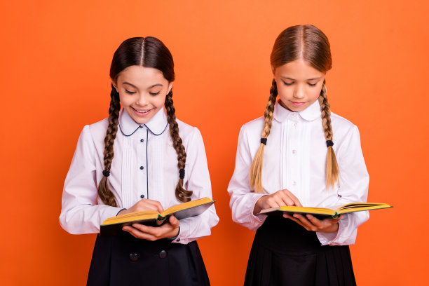 两个人的肖像好看迷人可爱可爱可爱愉快集中集中的十多岁的女孩准备测试听写孤立在明亮生动的亮橙色背景图片下载