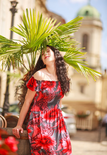 沉思的女人穿着鲜艳的长裙在古老的欧洲旅游城市的街道上图片下载