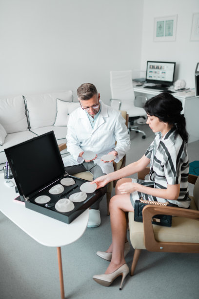 整形外科医生向女性展示不同尺寸的植入物图片下载