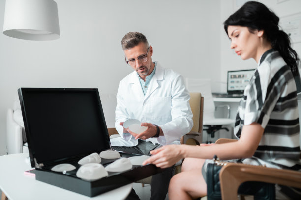 整形外科医生和女商人选择合适的乳房植入物图片下载