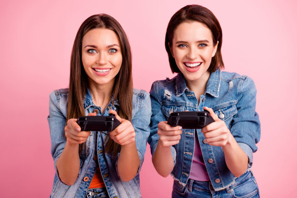 近距离的照片美丽的朋友，她，她的最好的女士，寒冷的心情，手，手臂，手表屏幕，获胜，胜利，视频游戏玩家比赛，穿牛仔裤，牛仔夹克，运动夹克，孤立的亮粉色背景图片下载