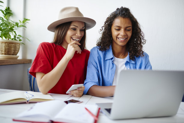 多种族的女学生在休息期间在笔记本电脑上观看社交网络视频，非洲裔美国女孩与最好的朋友笑着看上网本上浏览的图片图片下载