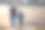 年轻的父亲和儿子携手走在草地上模糊的雾绿树和蓝天的背景。积极的生活方式，家庭关系，周末活动理念。图片下载