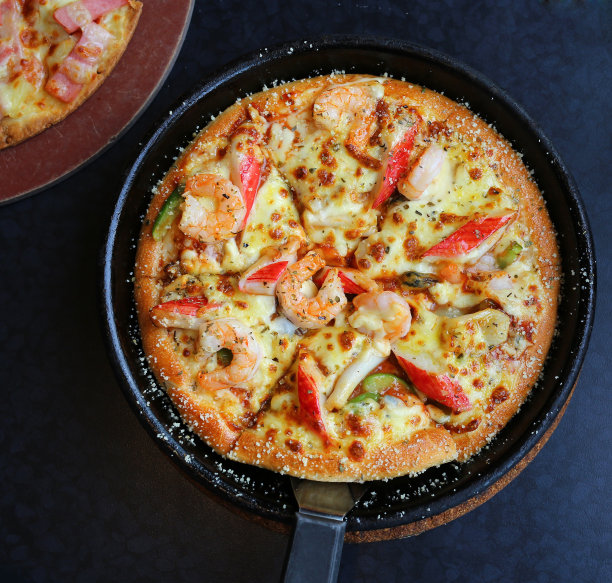 美味的海鲜披萨在托盘上的桌子图片下载