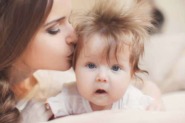 肖像快乐年轻有吸引力的母亲躺在床上的孩子在家里图片下载