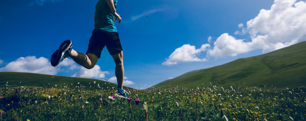 在草原山上奔跑的女子越野赛选手图片下载