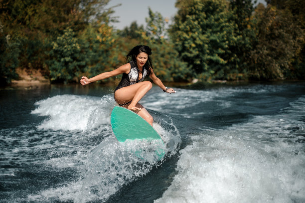 靠近海岸的冲浪板上的运动冲浪女孩图片下载