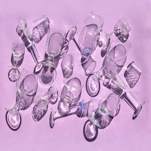 不同形式的空酒杯，葡萄酒，威士忌，热葡萄酒，伏特加，白酒躺在阳光和阴影的粉红色背景。最小的风格模式。艺术设计。俯视图，平放图片下载