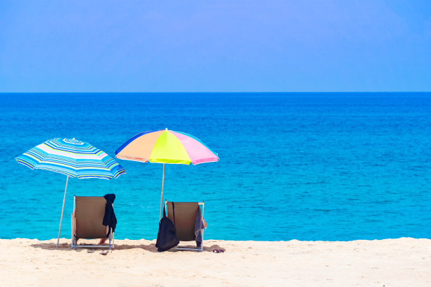 泰国普吉岛夏日海滩风景，在干净的白色沙滩和蓝色大海上的一把雨伞中间放松度假图片下载