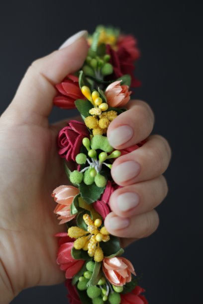 手握一个人造花圈的特写图片下载