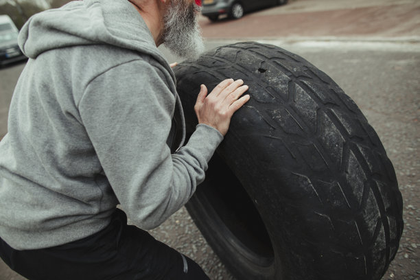 坐在轮胎上的人的中部图片下载