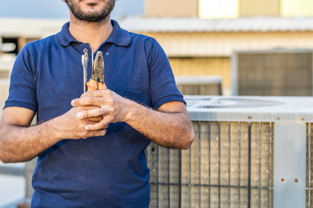 专业电工在屋顶用工具维修空调图片下载