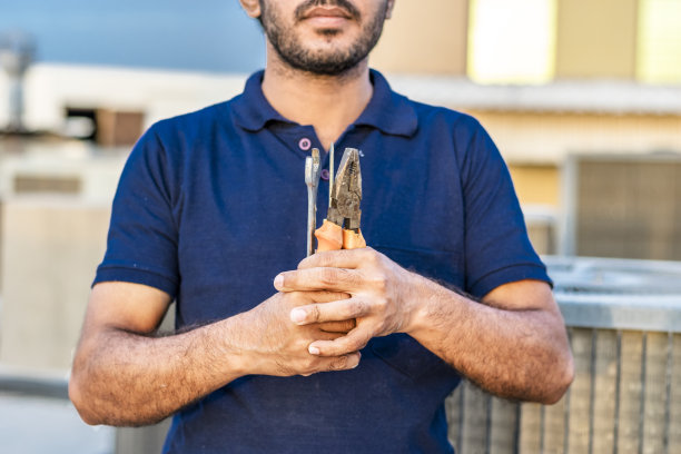 专业电工在屋顶用工具维修空调图片下载