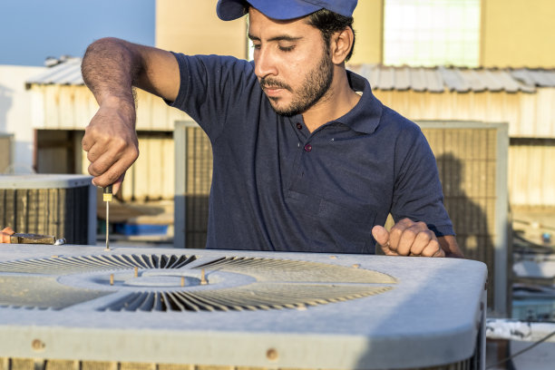 专业电工在屋顶用工具维修空调图片下载